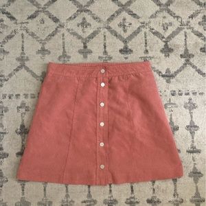 Pink mini skirt with snap buttons on front.